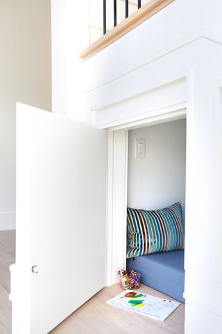 A cubby hole reading nook under the stairs