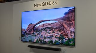 A Samsung Neo QN800 QLED 8K TV wall-mounted with a sound bar underneath.