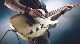 Detail of a hard rock musician playing a worn Fender electric guitar, taken on November 26, 2014.