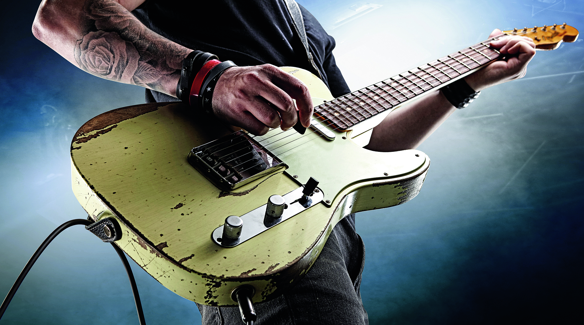 Detail of a hard rock musician playing a worn Fender electric guitar, taken on November 26, 2014.