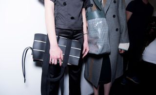 A close-up of a a checkered black and white bag, with a black and white stripe clutch.