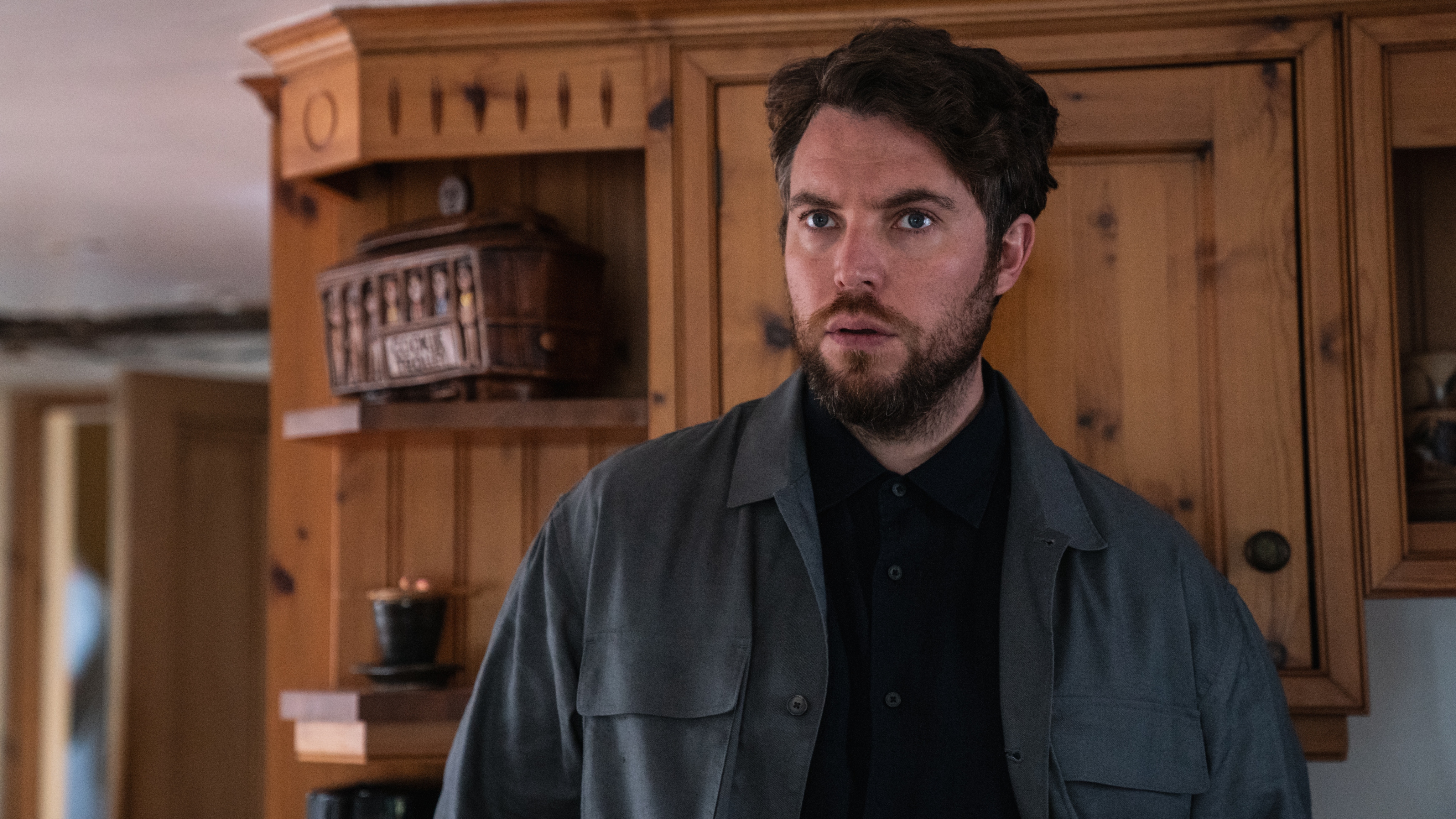 James in his sister's kitchen looking worried 