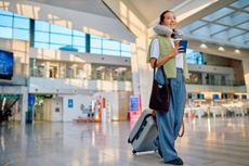 Woman traveling walking in modern airport terminal
