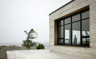 Exterior of Shift Cottage with wooden walls and glass windows