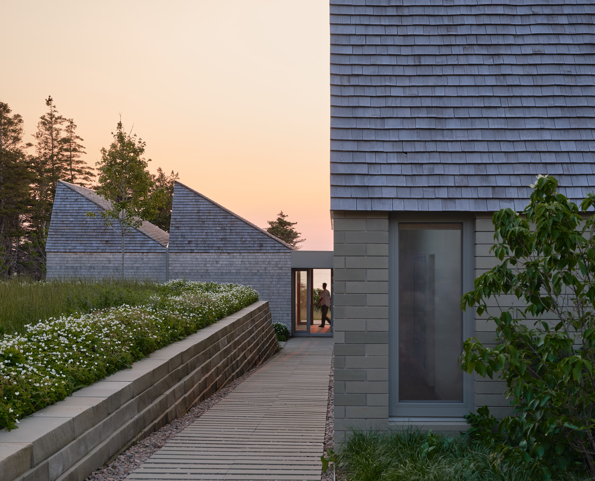 place of work's house in a meadow between the forest and the sea, an architectural, geometric house in leafy countryside