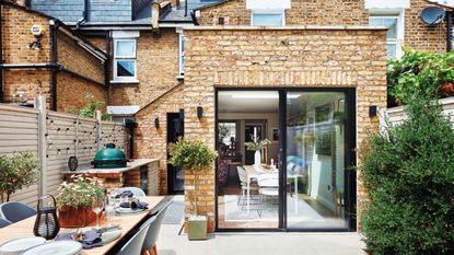 Back garden patio with dining table and chairs, surrounded by garden landscaping