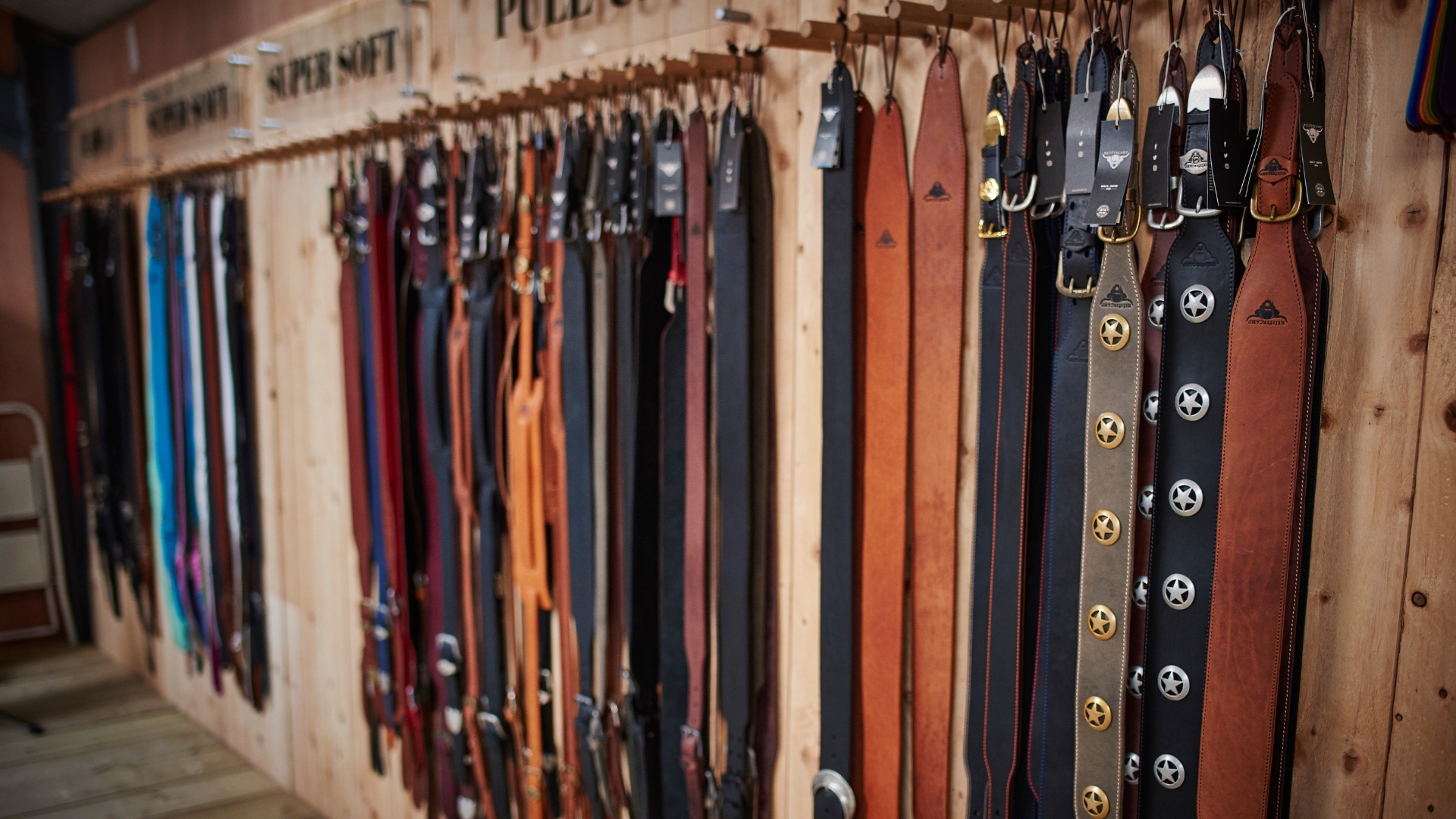 A selection of guitar straps hanging up in a strap factory