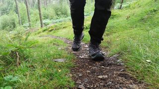 Person hiking on trail wearing Merrell Moab 3 Mid GTX boots