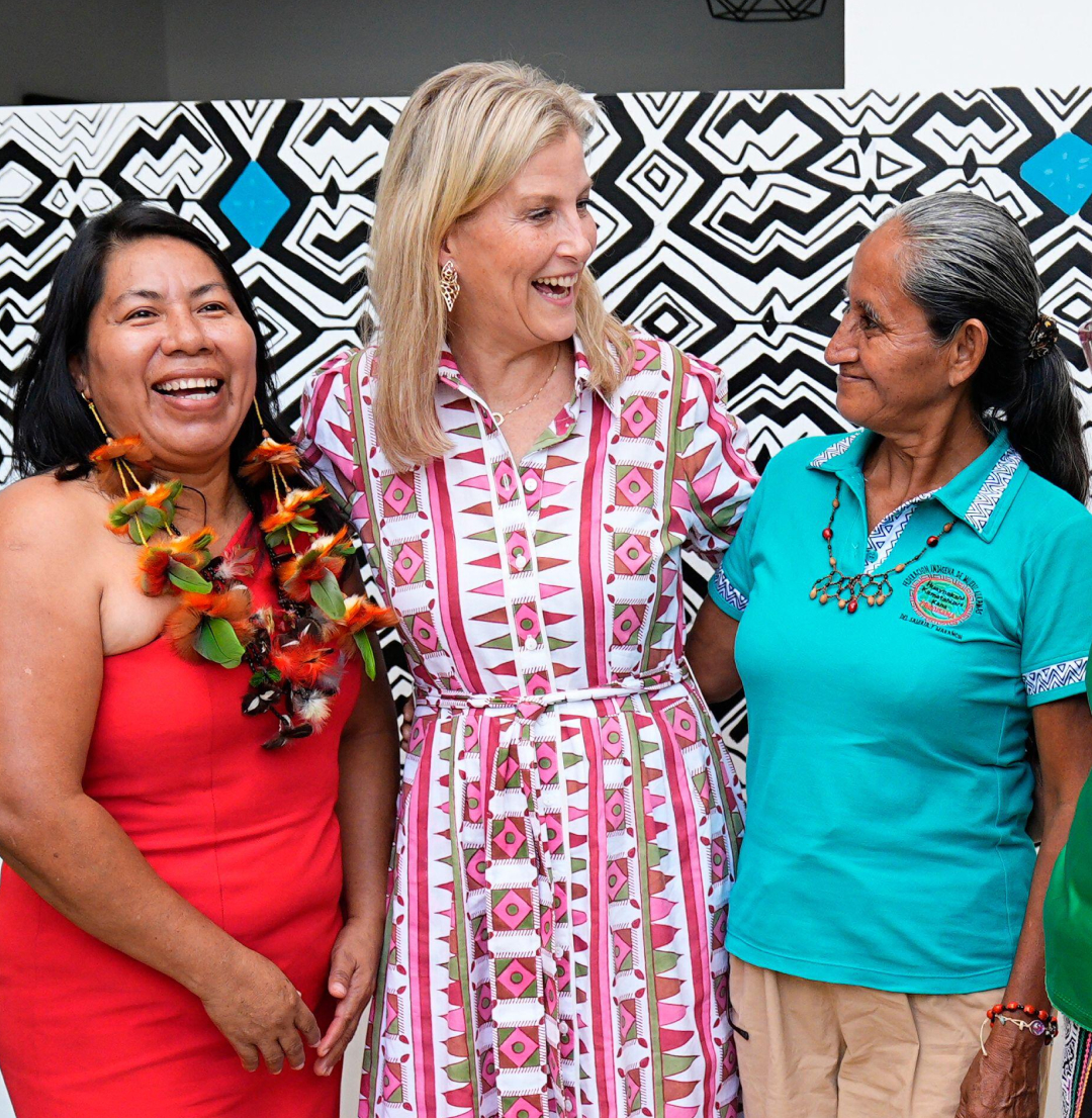 Duchess Sophie wearing a patterned shirt dress with her arms around three ladies and laughing
