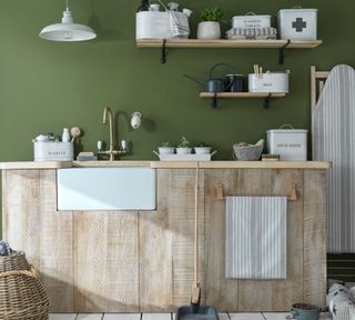 a green utilty room with rustic storage including wooden cabinets and wooden open shelves