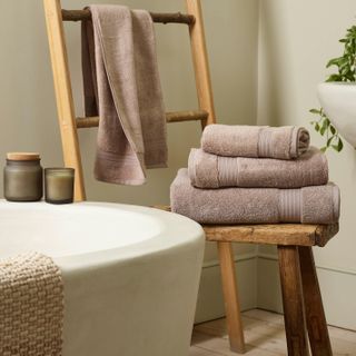 bathroom with pile of towels on a stool