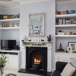 Living room with open fire place and bookshelves on wall