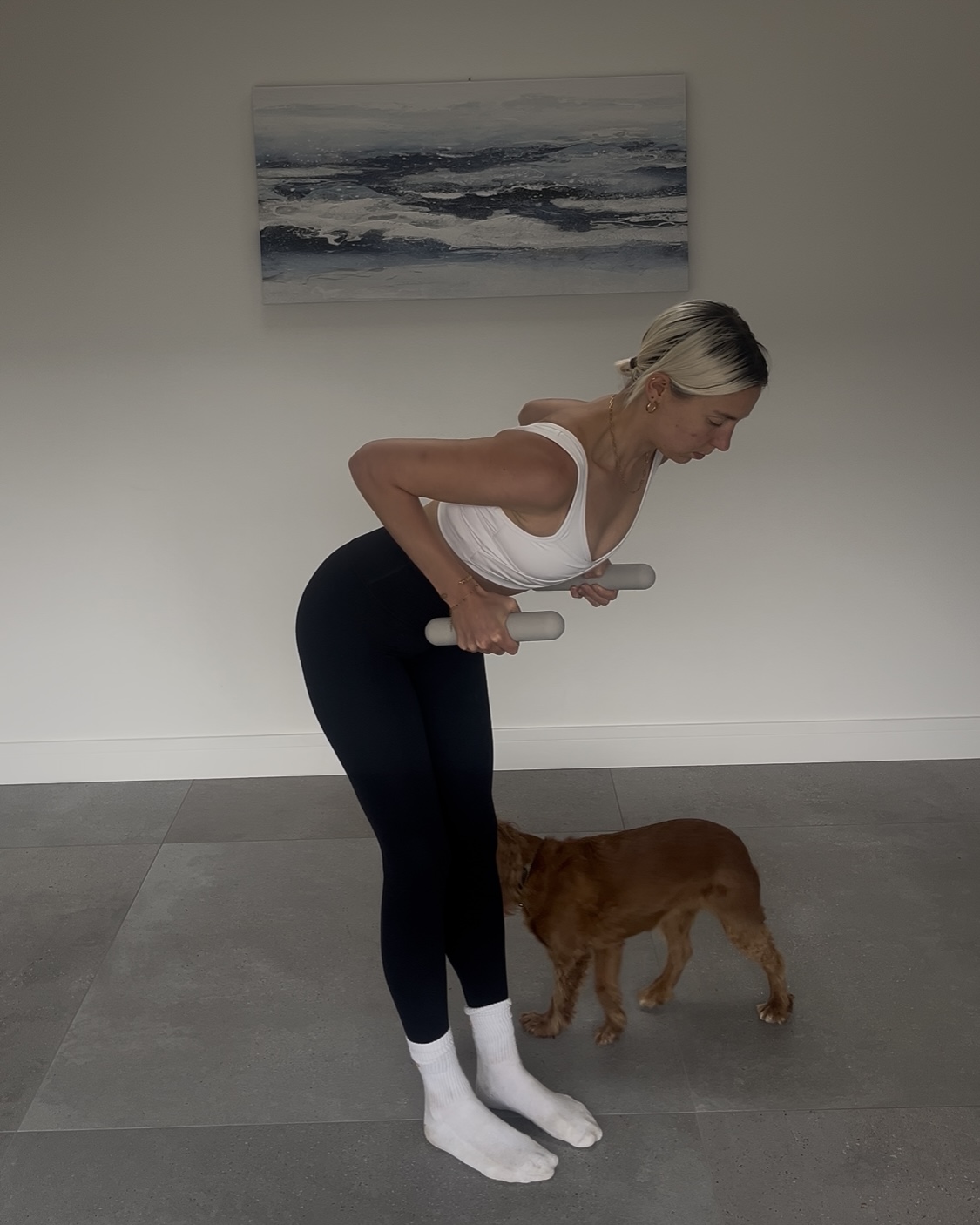 A woman practicing a standing upper body row with hand weights