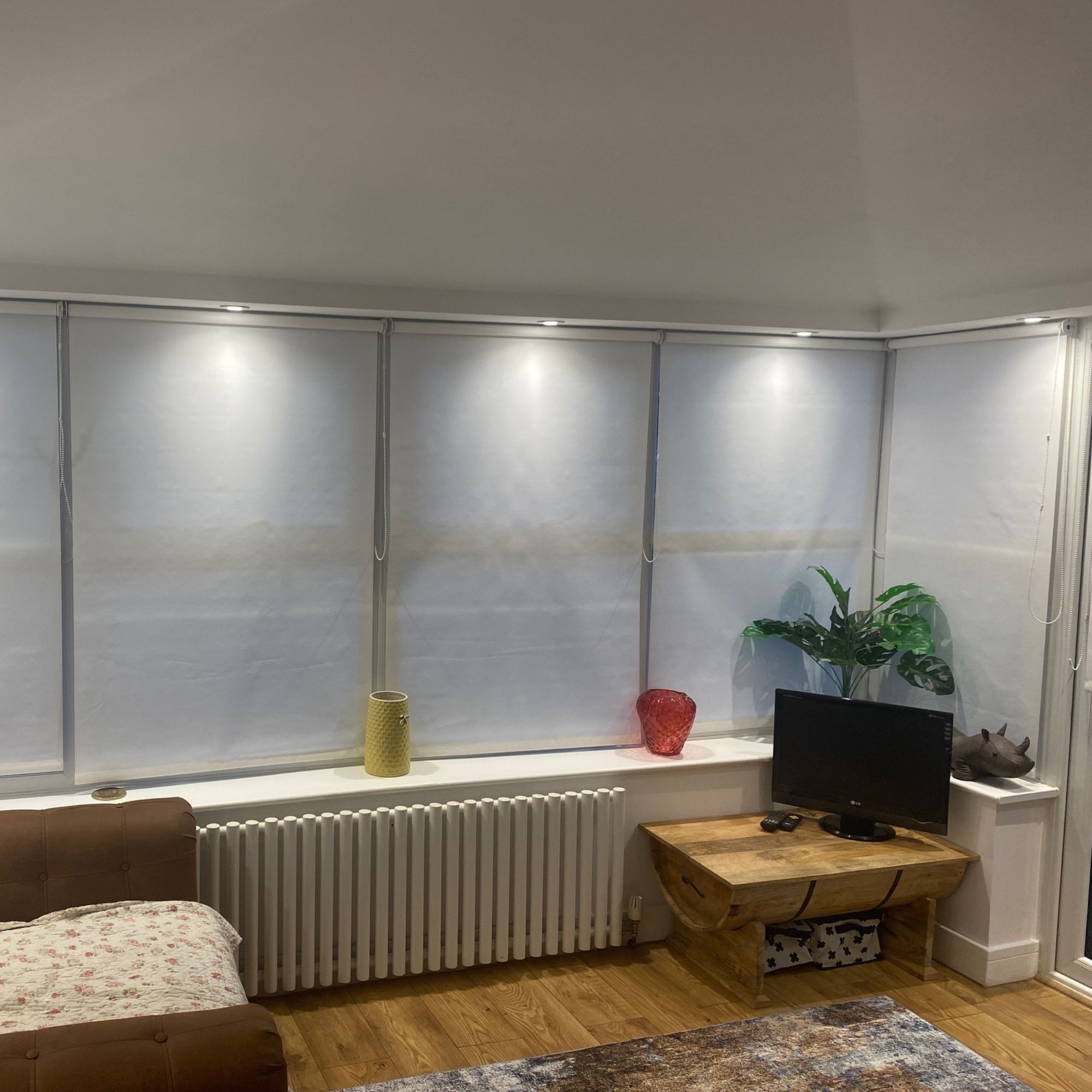 The finished conservatory room, with pelmet spotlights, blinds, chair coffee table and small TV