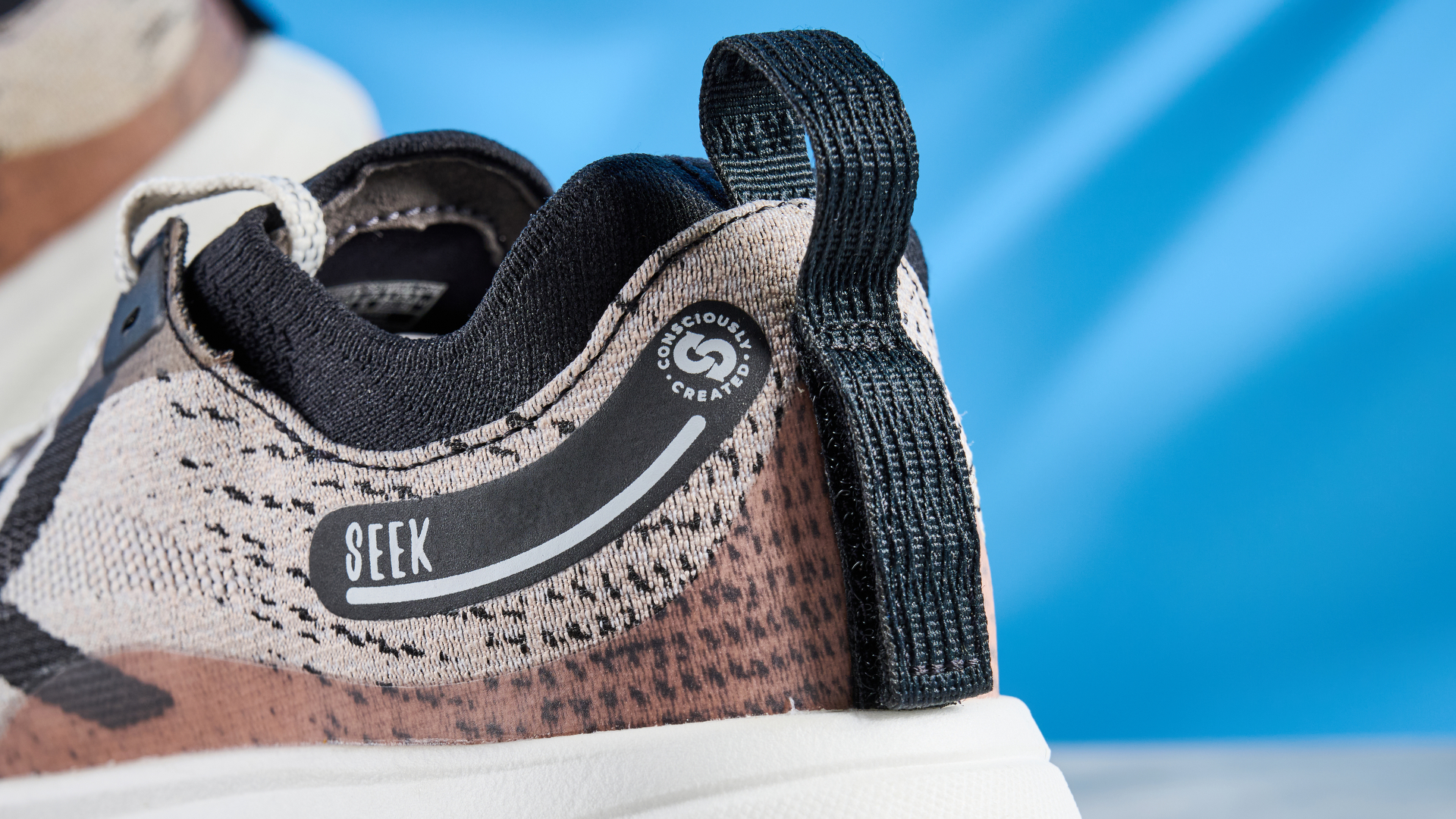 the keen seek trail shoes in brown, black, and beige photographed against the blue tom's guide background