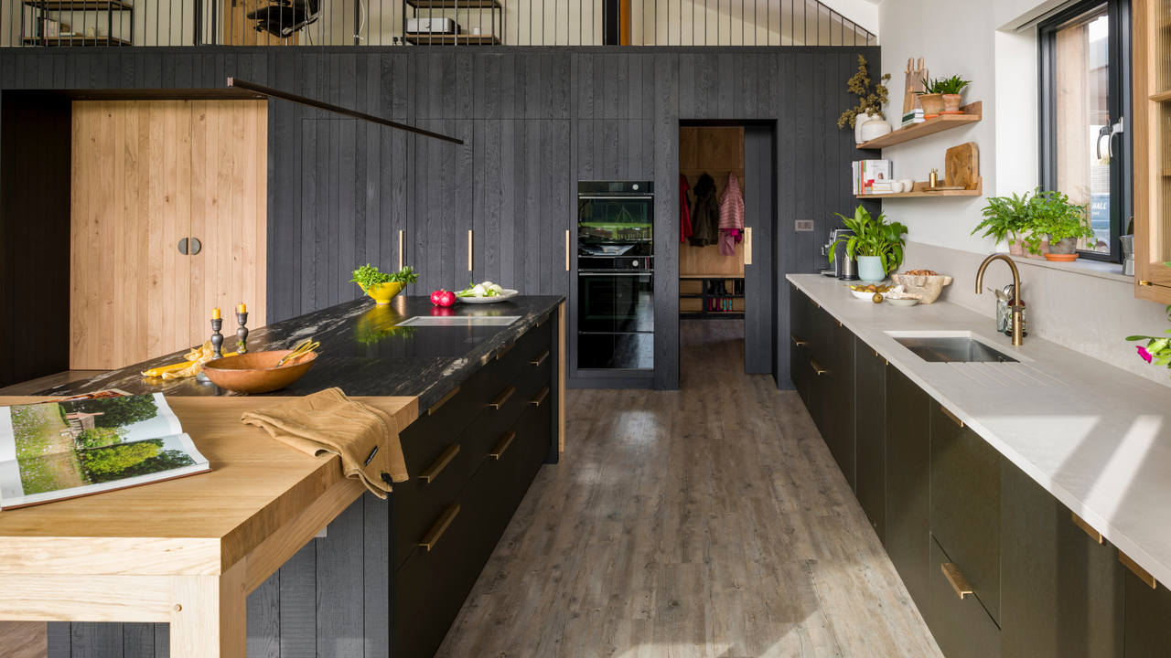 beautiful, big kitchen with wooden beams across the ceiling, sawn wood cabinetry and black cabinetry