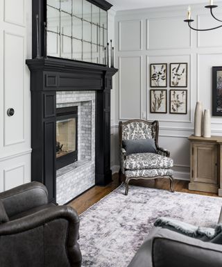 Living room with gray patterned armchair, leather armchair, corner of couch, gray rug and fireplace