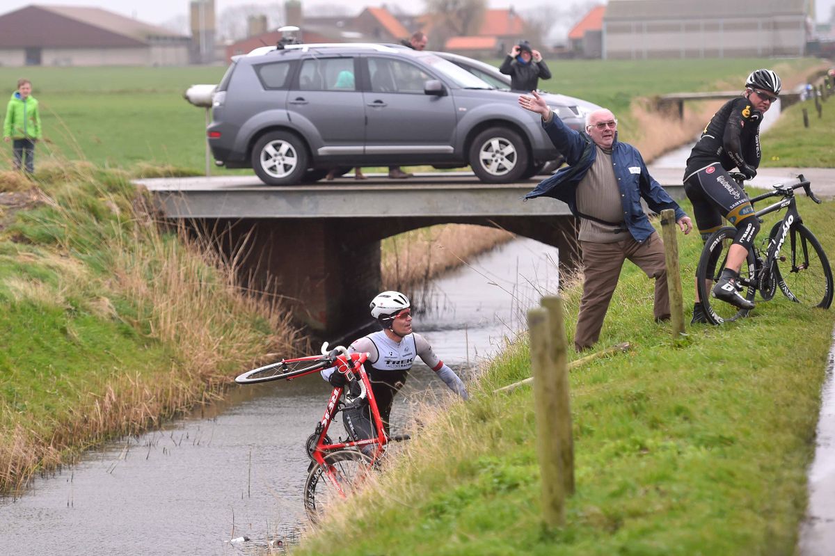 Gert Steegmans (Trek) carrying his bike just moments before dropping it into the water