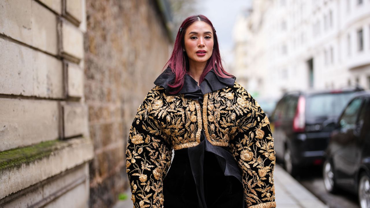 Heart Evangelista wears a black and gold oversized jacket, a black velvet mini skirt