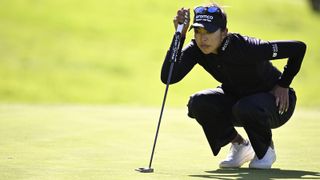 Alison Lee lining up a putt