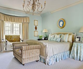 vintage blue bedroom with furniture skirts and lots of antique furniture and decor