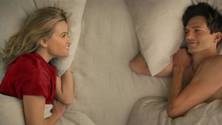 (L to R) Debbie (Reese Witherspoon) and Peter (Ashton Kutcher) lie in bed in Your Place or Mine, coming to Netflix on February 10, 2023