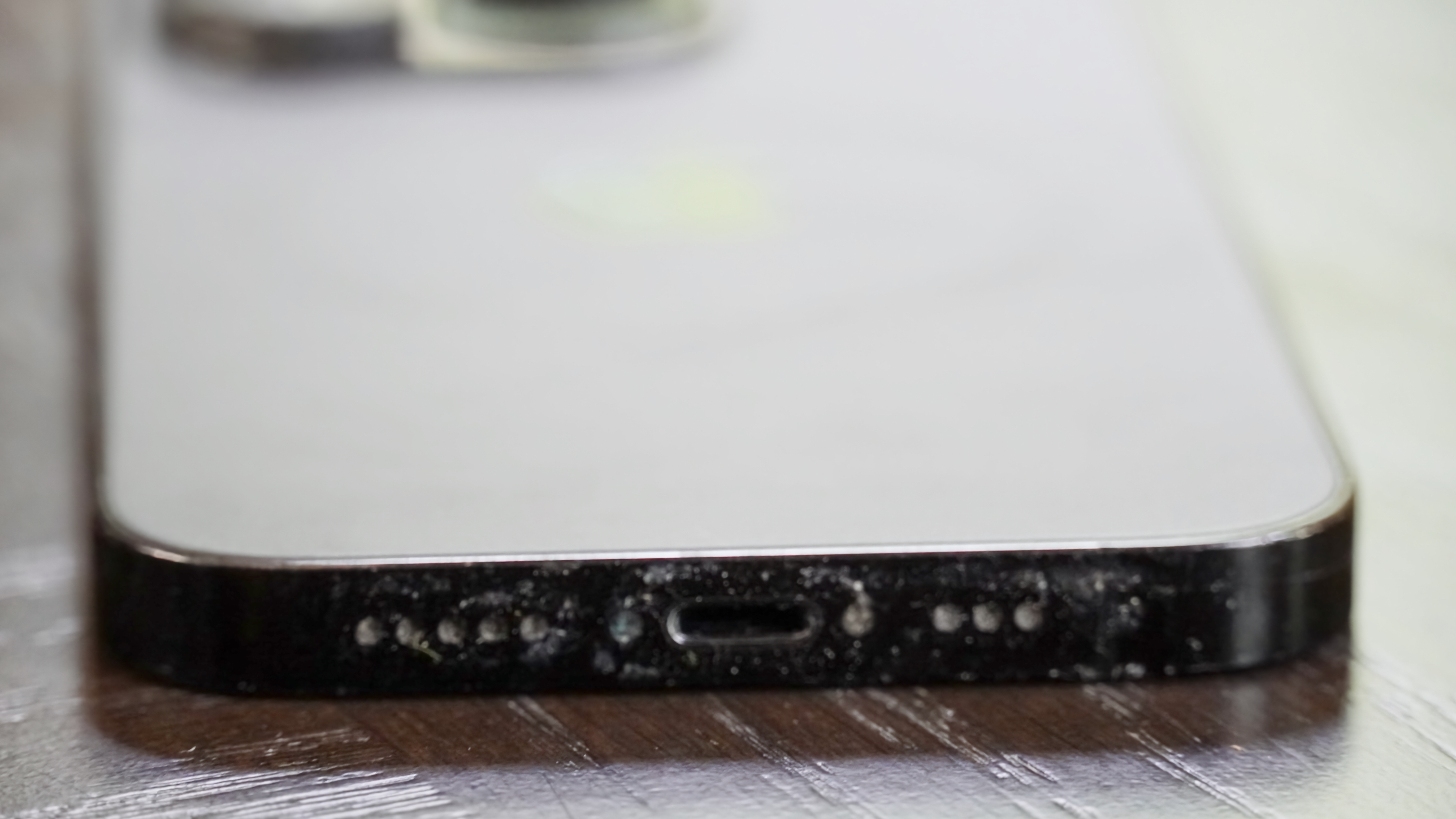 The bottom of my dad's iPhone 14 Pro before using the Otterbox Mobile Device Care Kit.