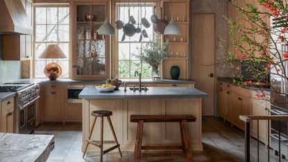 kitchen with wooden Shaker cabinets and an island with a steel gantry above and glazed concrete worksurfaces in 19th century four storey West Village townhouse