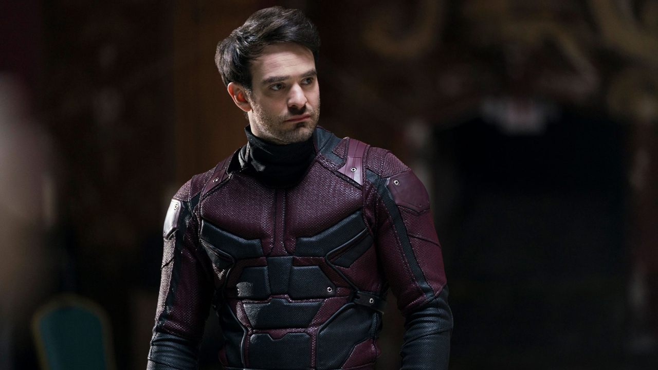 Un Matt Murdock desenmascarado se encuentra en una habitación oscura con el traje de Daredevil puesto en la serie de Netflix del personaje