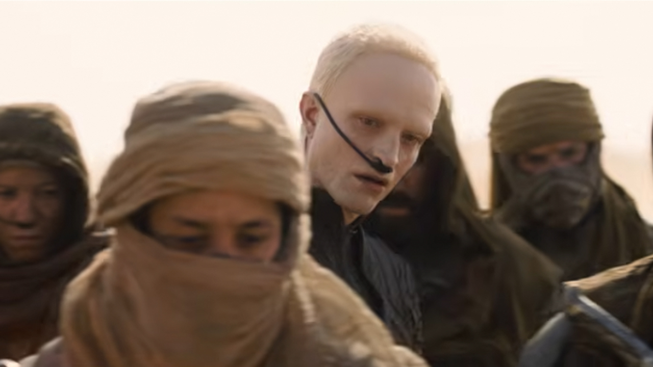 Robert Pattinson with blonde hair among a group of Fremen.