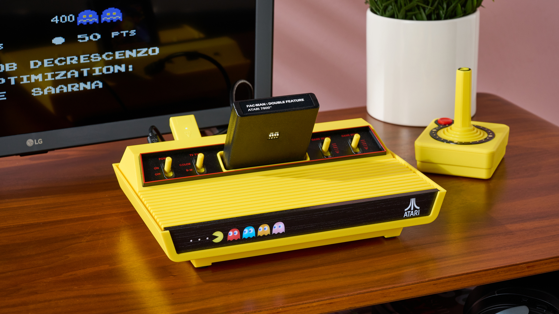 A closeup of the Atari 2600+ Pac-Man Edition and CX40+; a small amount of Pac-Man 7800 can be seen on the screen.