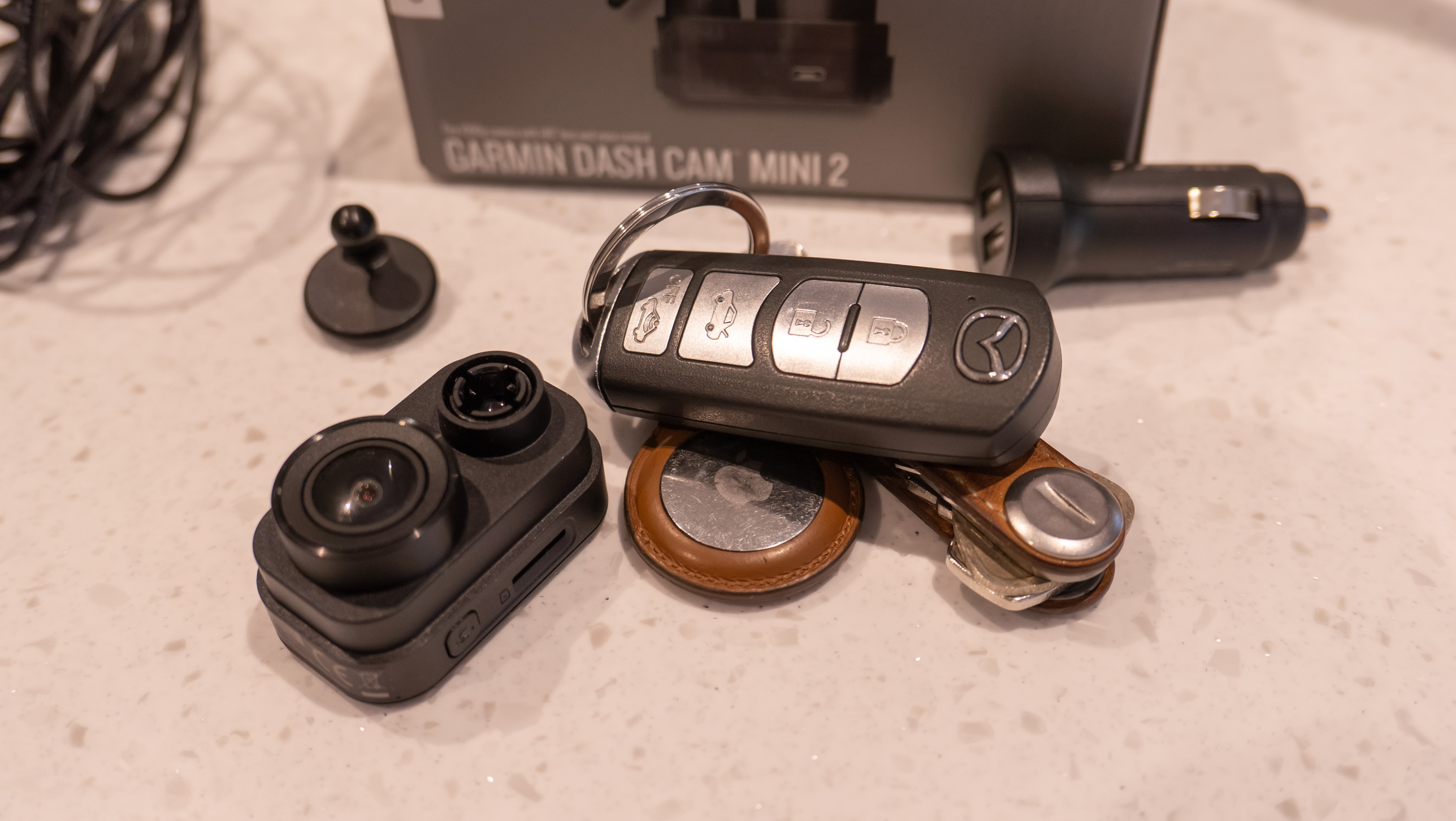 The Garmin Dash Cam Mini 2 next to its box on a table