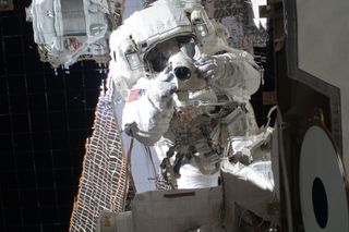NASA astronaut Michael Fincke, STS-134 mission specialist, uses a digital still camera during the mission's third spacewalk outside the International Space Station on May 25, 2011.
