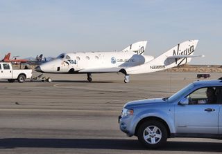 SpaceShipTwo is towed back to the hangar Jan. 13, 2011 under the watchful eye of East Kern Airport District Security Chief Mike Sterbens after a successful drop test and landing at the Mojave Air and Space Port in California.