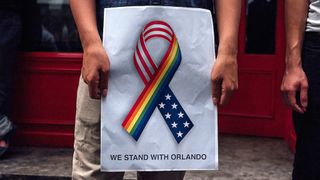 Man holding a poster in the aftermath of the Orlando shootings