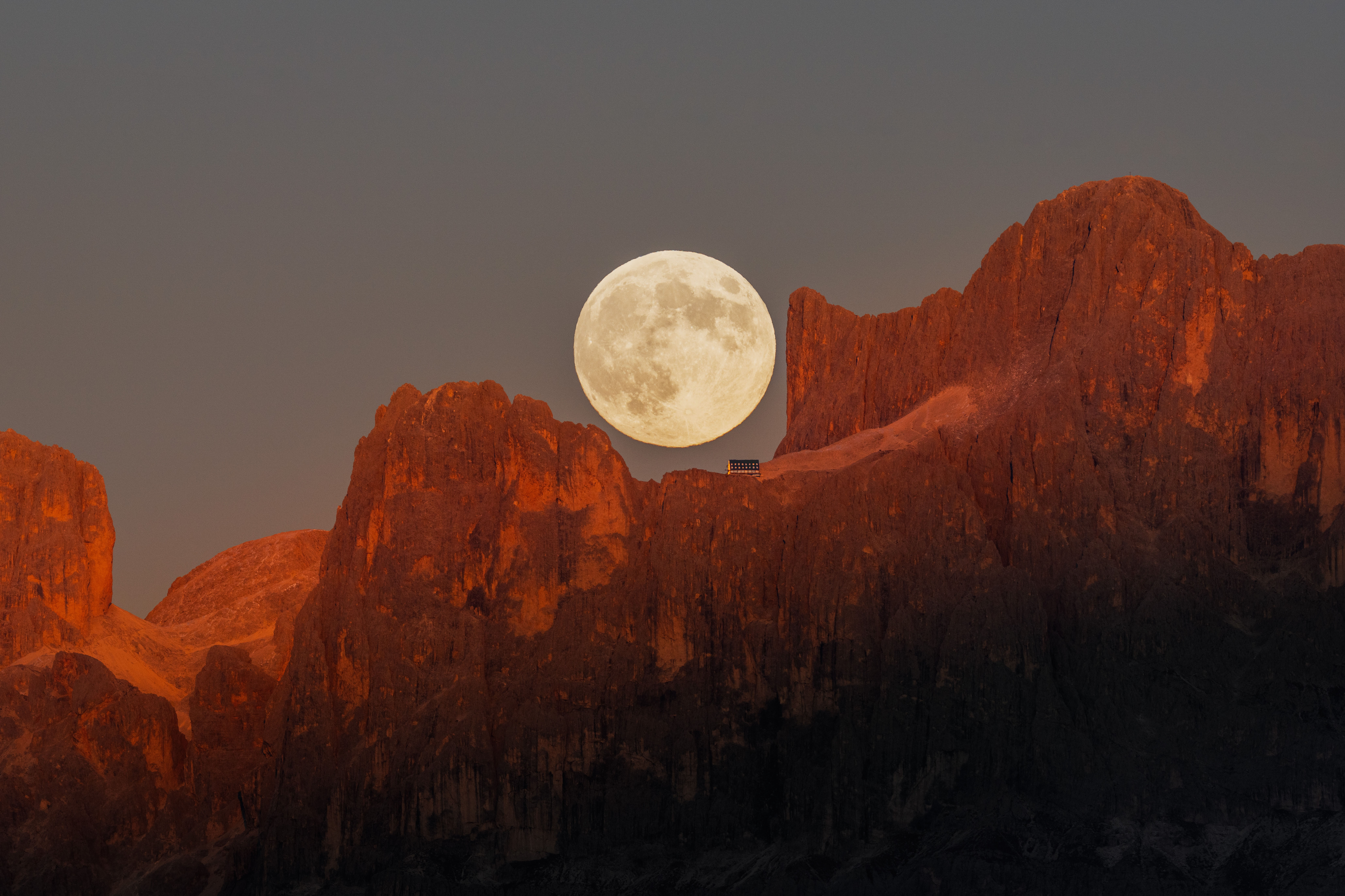 A full moon hangs over the Dolomite peaks