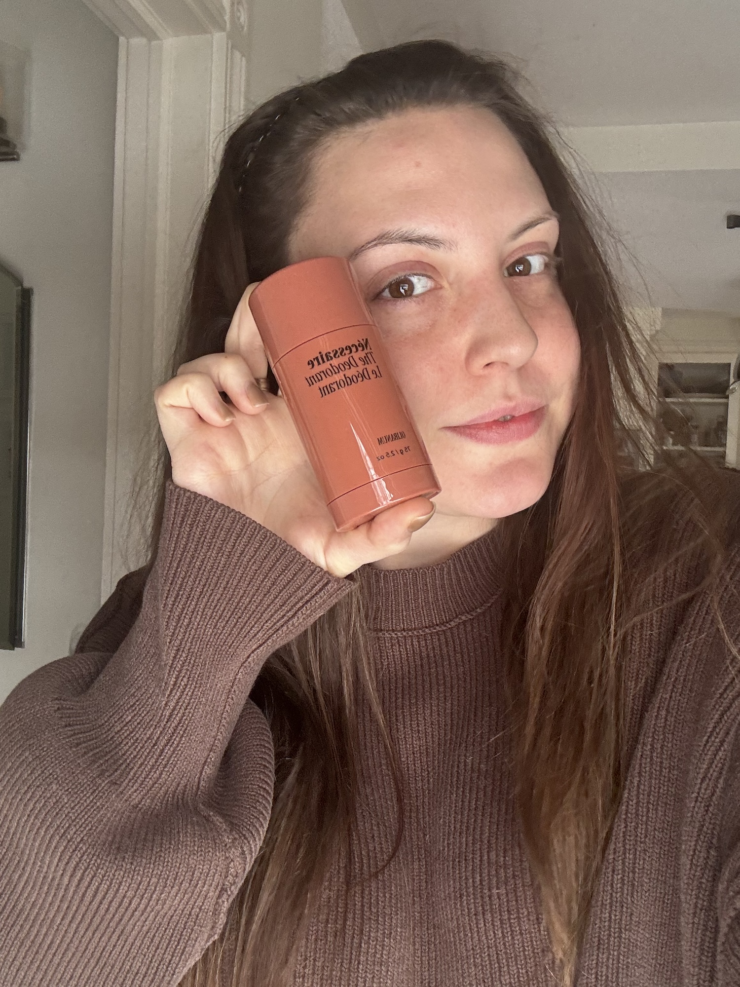 Sophia Vilensky holding a tube of Necessaire Deodorant before testing.