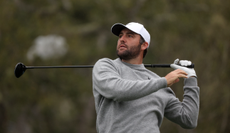 Scottie Scheffler watches a shot from the fairway