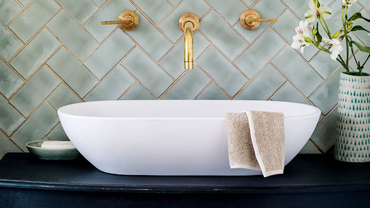 Green tiles and gold wall mounted taps