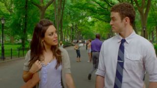 Mila Kunis in a blue top talking to Justin Timberlake in a tie while walking in Central Park in Friends With Benefits.