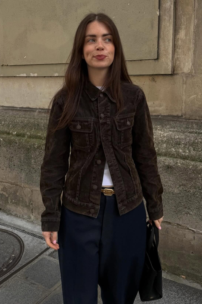 a woman wearing a brown suede jacket, black pants