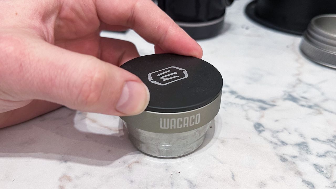 The Wacaco Picopresso tamp being used to tamp with the dosing funnel in place
