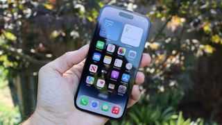 L'iPhone 14 Pro tourné vers l'avant, tenu dans une main en biais