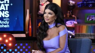 Teresa Giudice sitting on WWHL in a purple jump suit