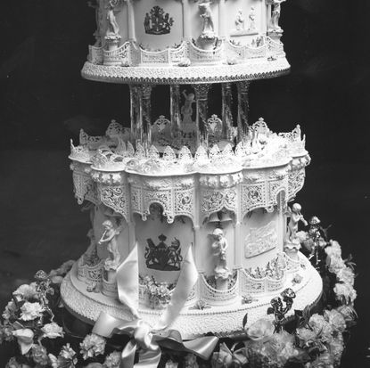 A tiered black-and-white wedding cake decorated with flowers