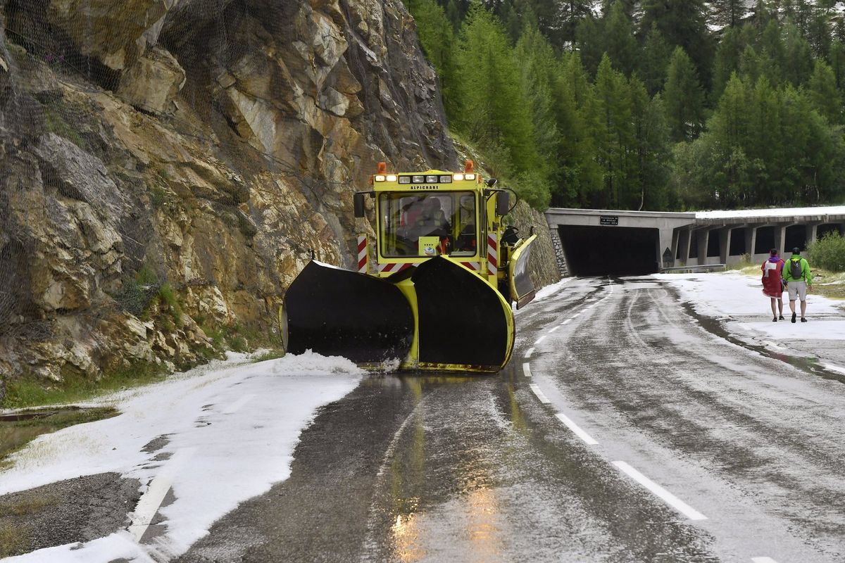 A snow plough tires to clear the road