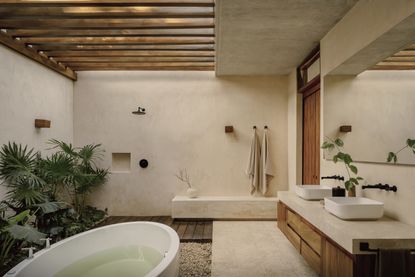 An outdoor bathroom with rough walls and a bathtub