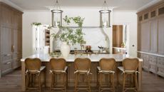 A large kitchen with dark wood cabinets, white walls, and marble countertops