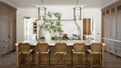 A large kitchen with dark wood cabinets, white walls, and marble countertops