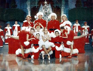 The cast of 'A White Christmas' in red santa suits